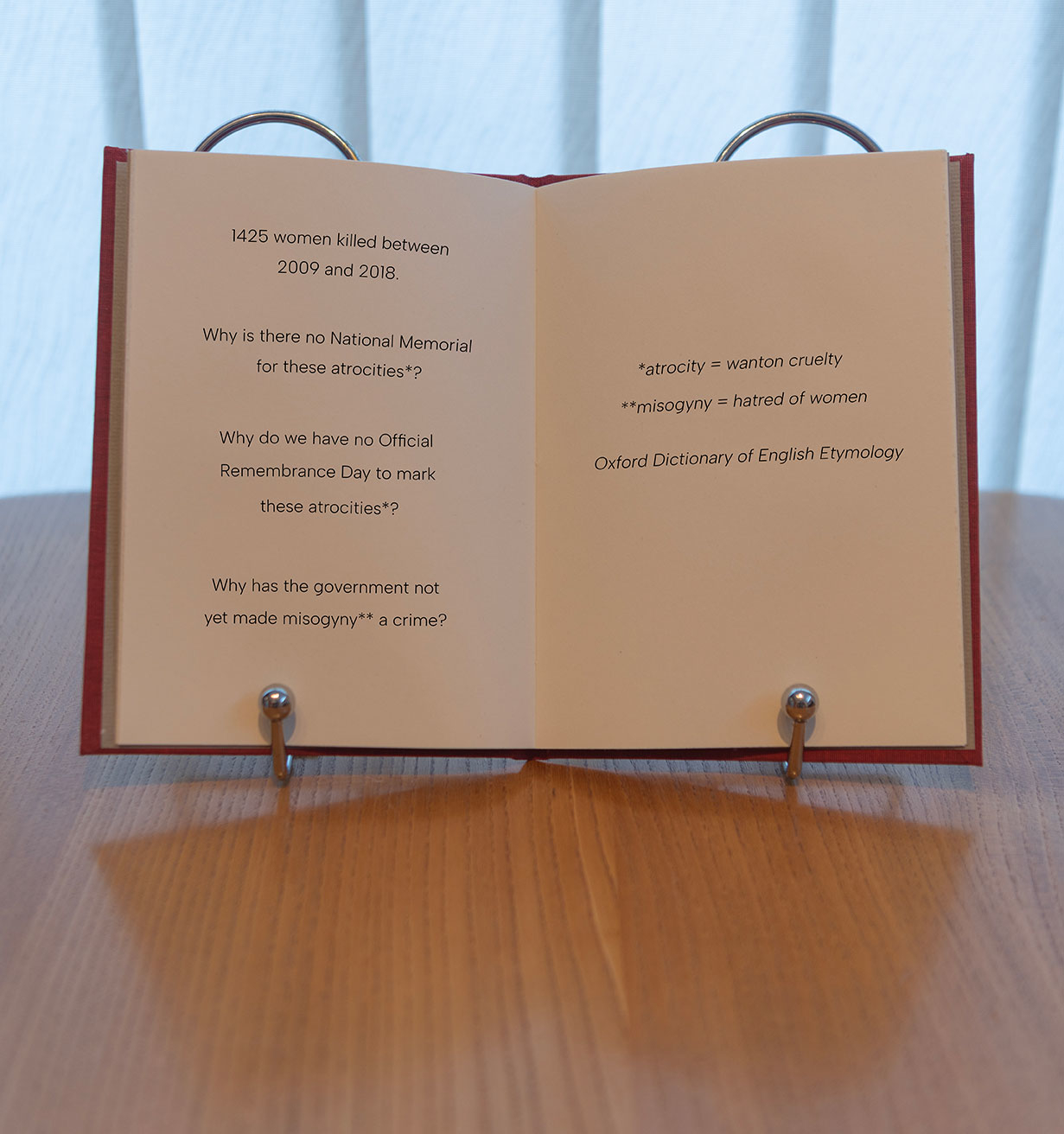 red book open on a stand with statements about femicide