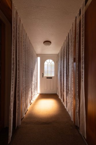silks hanging in hall illuminated with light from doorway