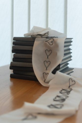 pile of books draped with heart-stitched silk